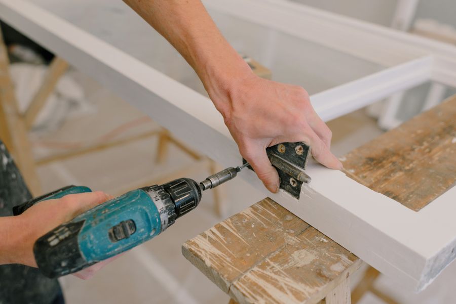 Handyman repairing a door hinge