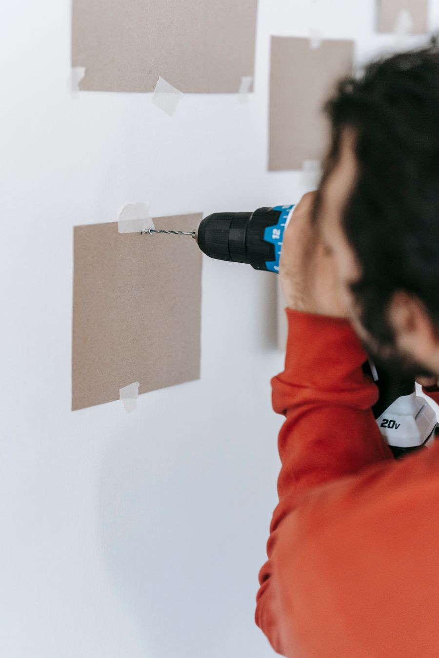 Handyman drilling a wall for a fitting